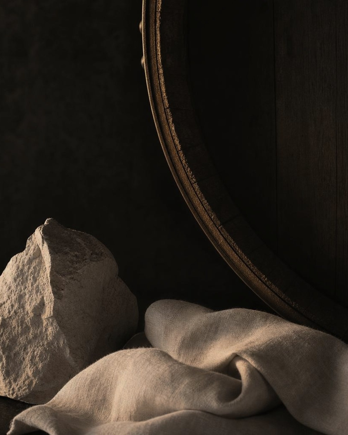 Chalky limestone, ivory linen and oak barrel detail in subdued gold light