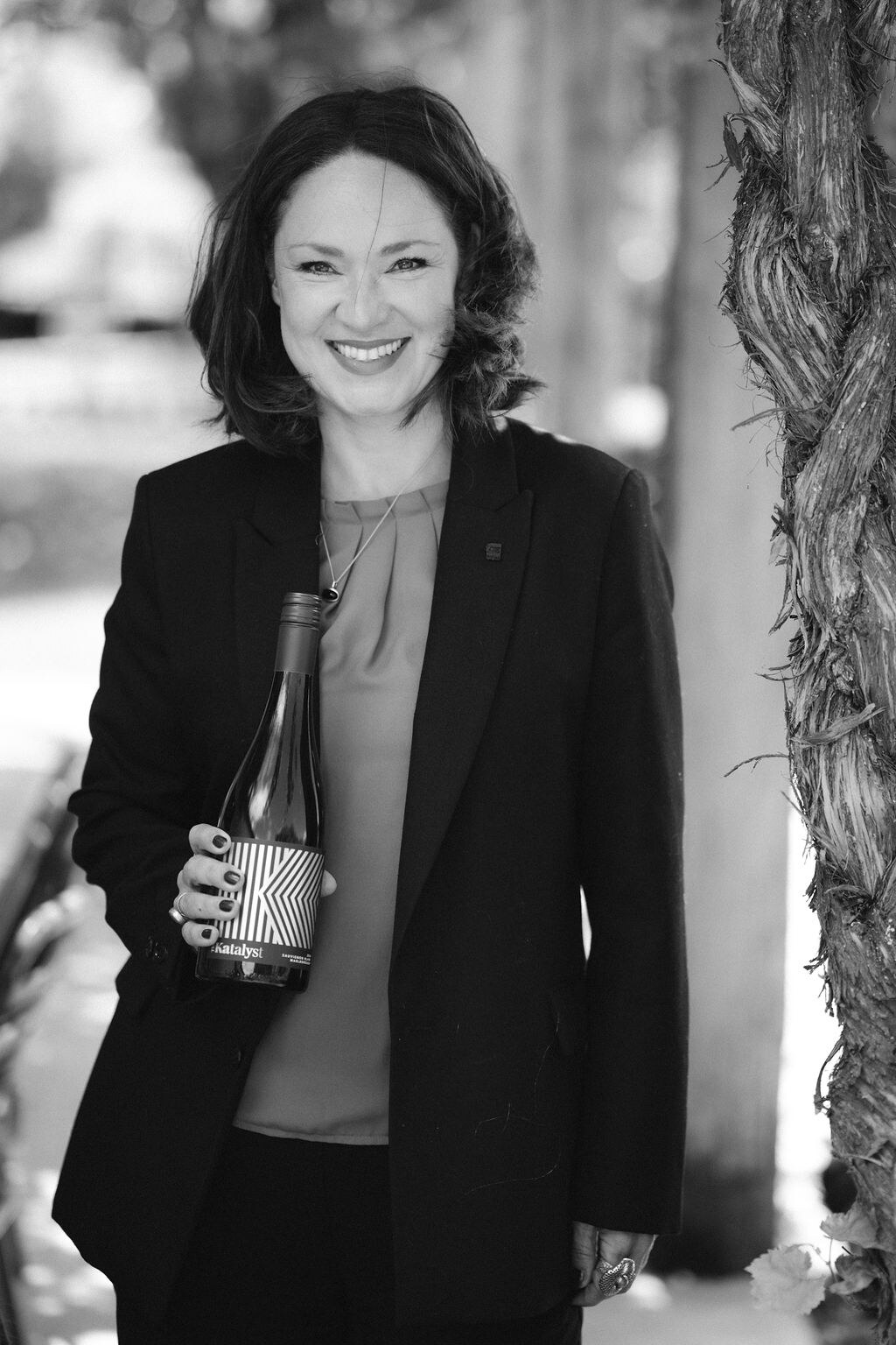 Kat Jankowiec, winemaker and founder of The Katalyst, holding a bottle of The Katalyst wine